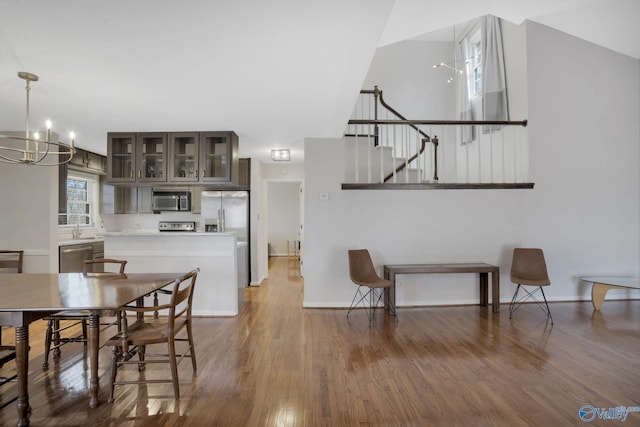 dining room with a chandelier, wood finished floors, and baseboards