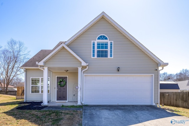 traditional-style house featuring driveway and fence