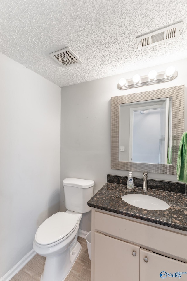 bathroom featuring toilet, wood finished floors, and visible vents