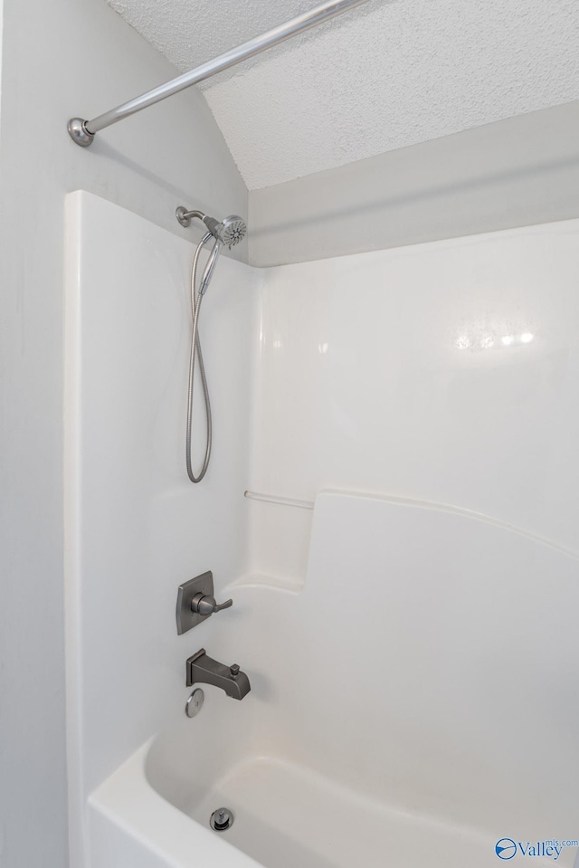 full bathroom featuring shower / bathing tub combination and a textured ceiling