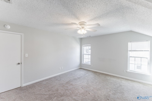 spare room with baseboards, carpet floors, a textured ceiling, and a ceiling fan