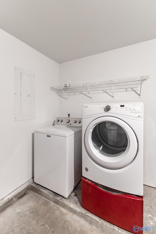 washroom featuring laundry area, electric panel, and washer and clothes dryer