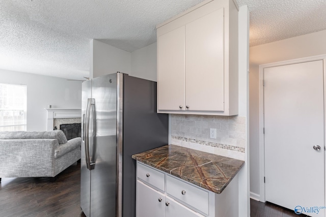 kitchen featuring stainless steel fridge, tile counters, dark wood-style flooring, and white cabinets