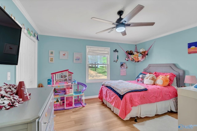 bedroom with light wood finished floors, baseboards, ornamental molding, and a ceiling fan