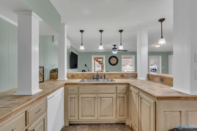 kitchen featuring tile counters, decorative light fixtures, dishwasher, and ornate columns