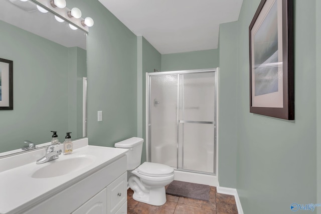 bathroom with baseboards, toilet, tile patterned floors, vanity, and a shower stall