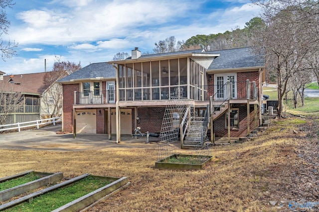 back of property featuring a sunroom, a chimney, stairway, and a vegetable garden