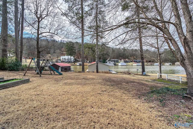 view of yard with a water view and a playground