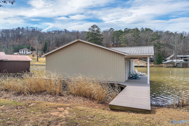 exterior space featuring a dock, a water view, and metal roof