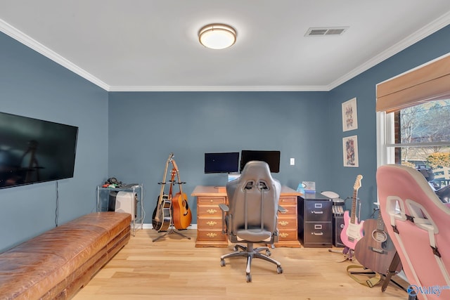 office space featuring light wood-type flooring, visible vents, ornamental molding, and baseboards