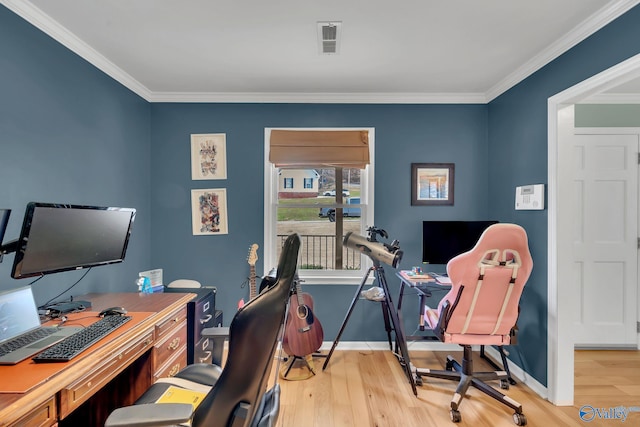 office space featuring light wood-type flooring, baseboards, visible vents, and crown molding