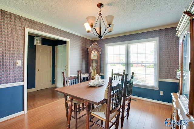 24430 Chadwick Dr, Athens, AL 35613 - dining area featuring wallpapered walls, ornamental molding, a textured ceiling, a chandelier, and light wood-type flooring