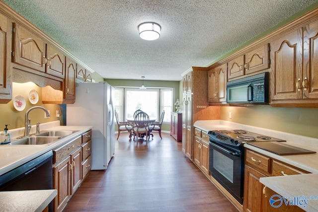 24430 Chadwick Dr, Athens, AL 35613 - kitchen with black appliances, a textured ceiling, light countertops, dark wood finished floors, and brown cabinets