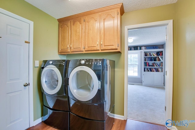 24430 Chadwick Dr, Athens, AL 35613 - laundry room with cabinet space, washer and clothes dryer, a textured ceiling, and light wood finished floors