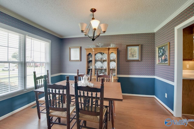 24430 Chadwick Dr, Athens, AL 35613 - dining space featuring crown molding, a chandelier, a textured ceiling, wood finished floors, and wallpapered walls