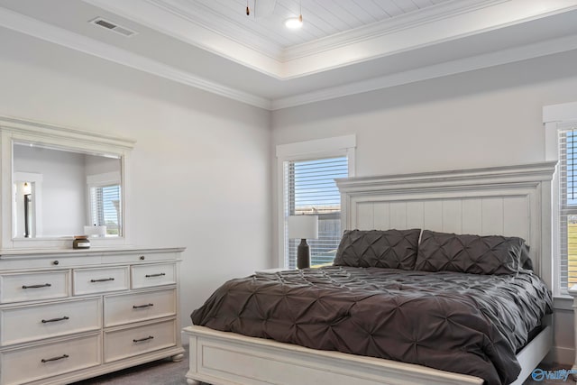 carpeted bedroom featuring ornamental molding and a raised ceiling