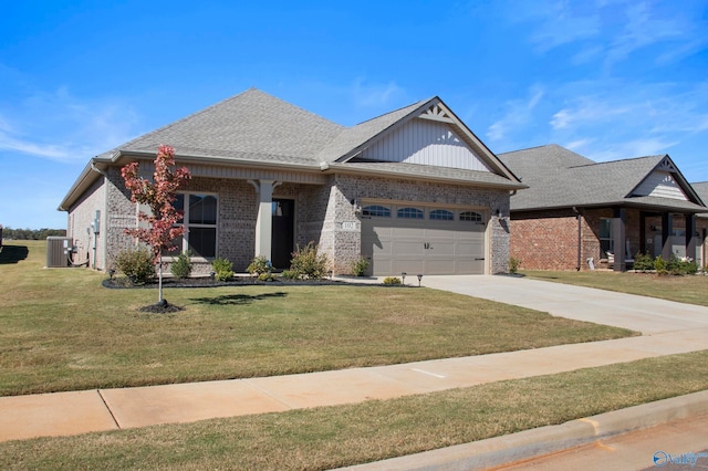 view of front of home with central air condition unit, a front yard, and a garage