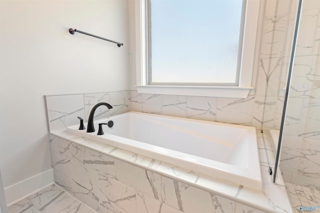 bathroom with a relaxing tiled tub