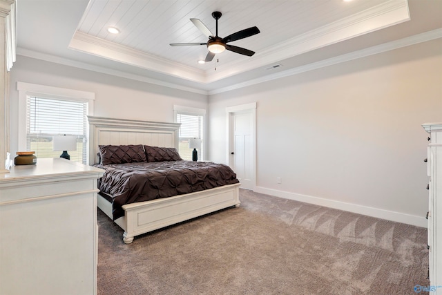 bedroom with ornamental molding, carpet, a tray ceiling, and ceiling fan