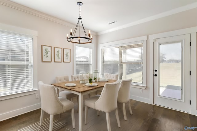 dining space with ornamental molding, a chandelier, and dark wood-type flooring