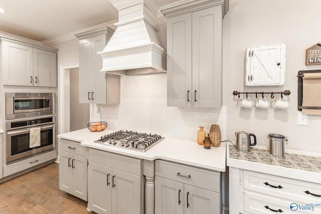 202 Maureen Dr, Madison, AL 35756 - kitchen with appliances with stainless steel finishes, custom range hood, light countertops, tasteful backsplash, and gray cabinetry