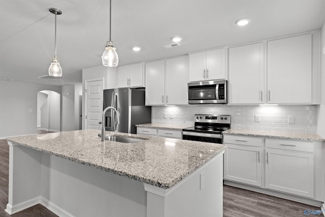 103 Gander Cir, Owens Cross Roads, AL 35763 - kitchen with stainless steel appliances, dark wood-style flooring, white cabinetry, arched walkways, and decorative backsplash