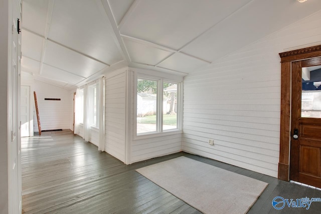 additional living space with wooden walls, lofted ceiling, and hardwood / wood-style flooring