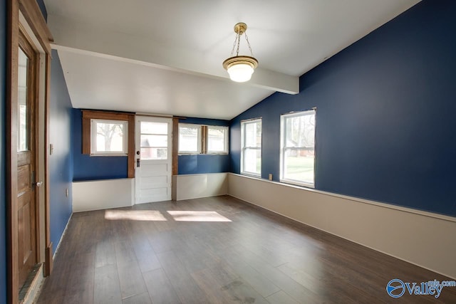 unfurnished room featuring dark wood-type flooring and lofted ceiling with beams