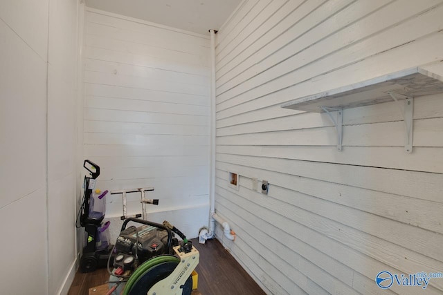 interior space with dark hardwood / wood-style flooring and wooden walls