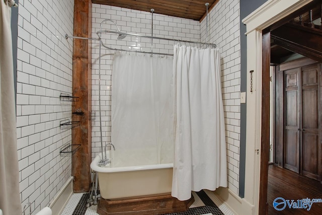 bathroom with tile walls and shower / bath combo