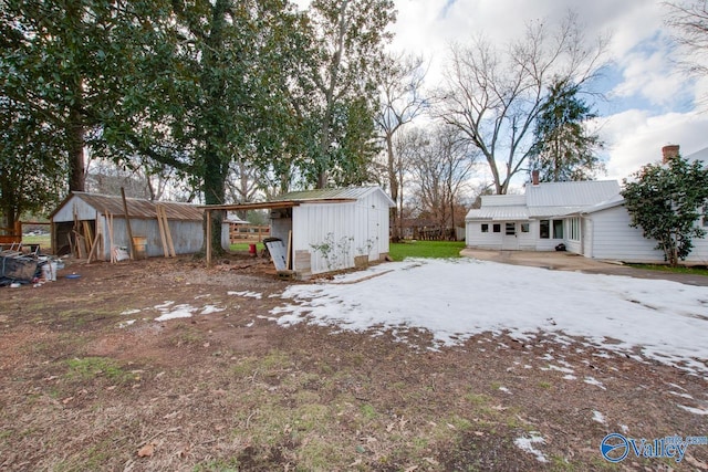 yard covered in snow featuring an outbuilding