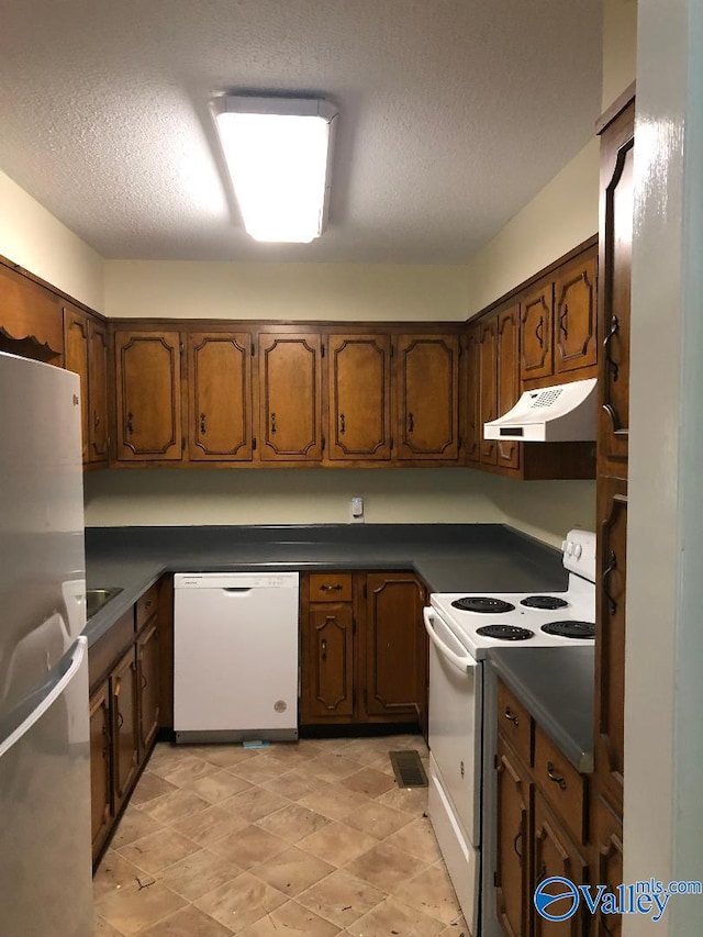 kitchen with white appliances and a textured ceiling