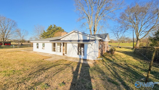 back of house featuring a lawn, a chimney, and fence