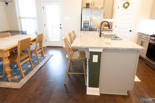 kitchen with dark hardwood / wood-style flooring, stainless steel appliances, a center island with sink, and sink