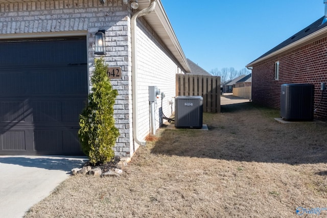 view of side of property with cooling unit and a garage