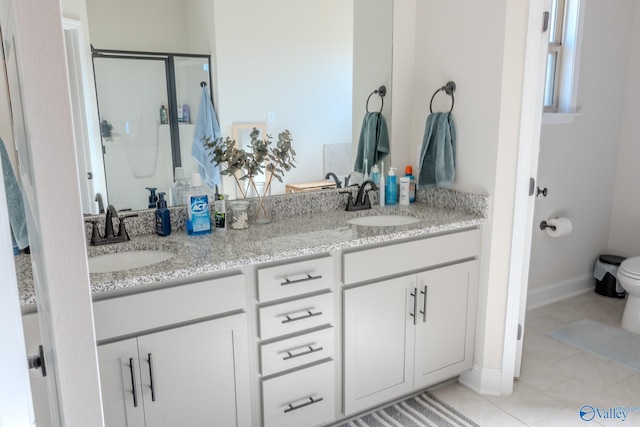 bathroom with tile patterned flooring, vanity, toilet, and walk in shower