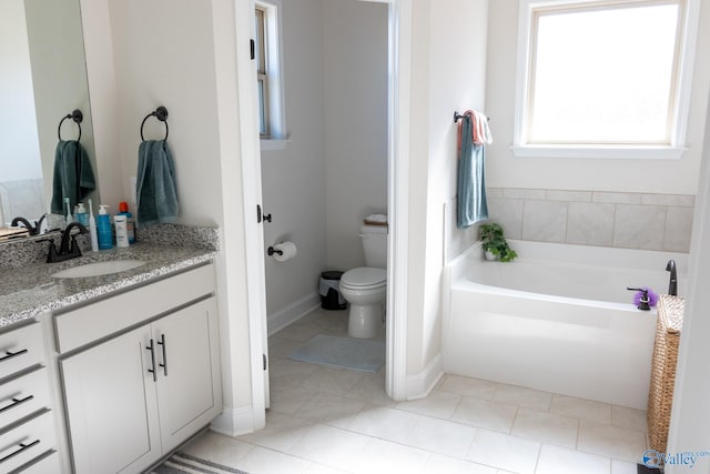 bathroom with tile patterned floors, vanity, toilet, and a bathtub