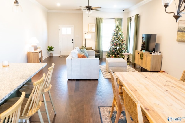 living room with dark hardwood / wood-style flooring, ceiling fan, and ornamental molding