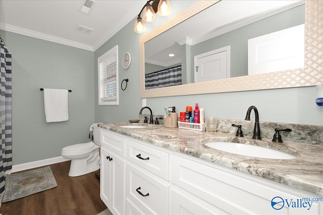 bathroom with toilet, crown molding, vanity, and hardwood / wood-style flooring