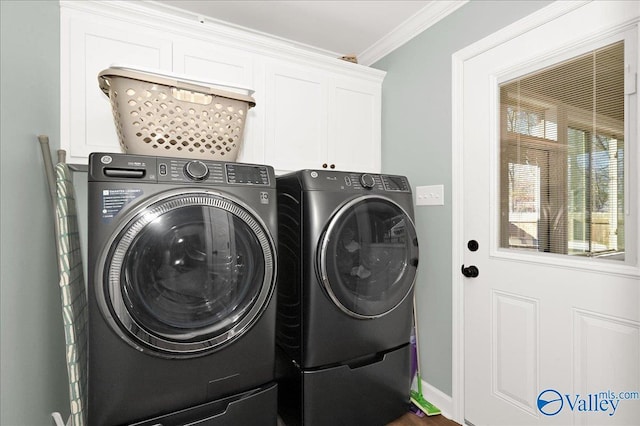 clothes washing area with washer and dryer, cabinets, and crown molding