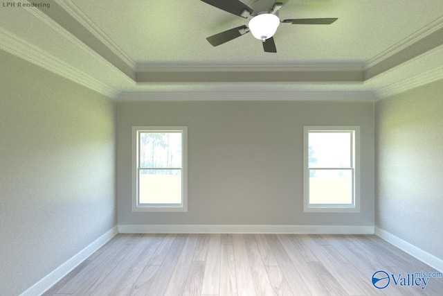 empty room with crown molding, a raised ceiling, baseboards, and wood finished floors