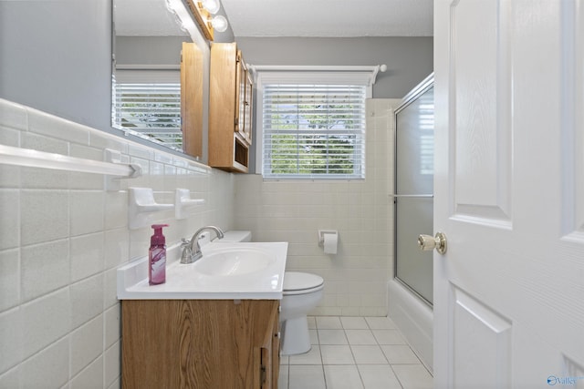 302 Cherry St NW, Hartselle, AL 35640 - bathroom with tile walls, vanity, tile patterned flooring, and shower / bath combination with glass door