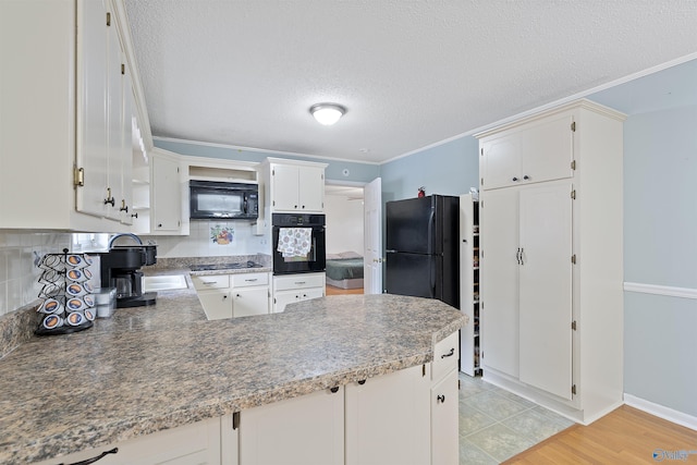 302 Cherry St NW, Hartselle, AL 35640 - kitchen with black appliances, tasteful backsplash, a peninsula, a textured ceiling, and white cabinetry