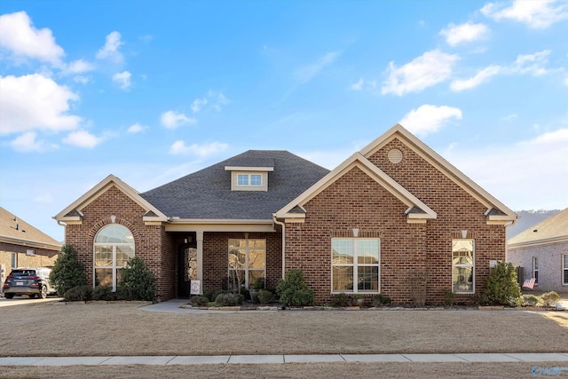 traditional home featuring brick siding and roof with shingles