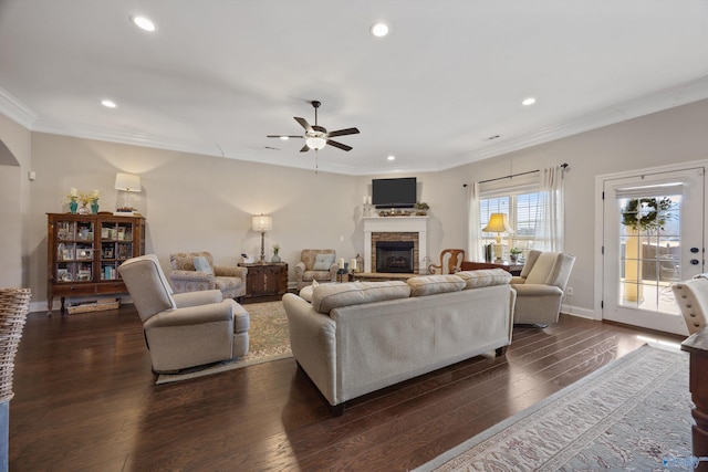 living room with recessed lighting, a fireplace, baseboards, dark wood-style floors, and crown molding