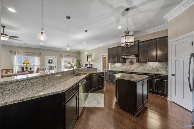 kitchen featuring pendant lighting, appliances with stainless steel finishes, dark wood-type flooring, a kitchen island with sink, and a sink