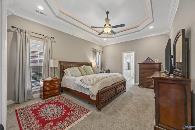 bedroom featuring crown molding, a raised ceiling, visible vents, and light colored carpet