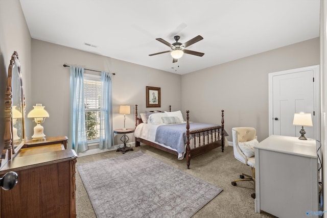 bedroom featuring a ceiling fan, visible vents, and light carpet