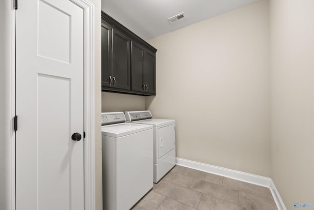 washroom with washing machine and dryer, visible vents, cabinet space, and baseboards