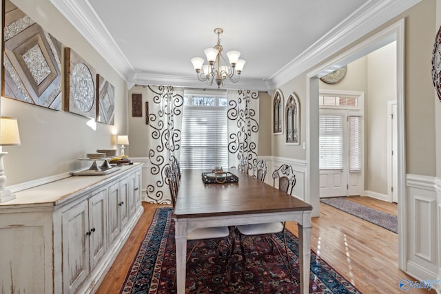 dining space with light hardwood / wood-style flooring, a healthy amount of sunlight, and ornamental molding